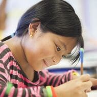 An elementary school student works at a desk.