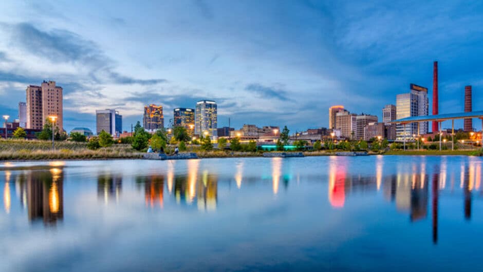 The skyline reflects in water in Birmingham. 