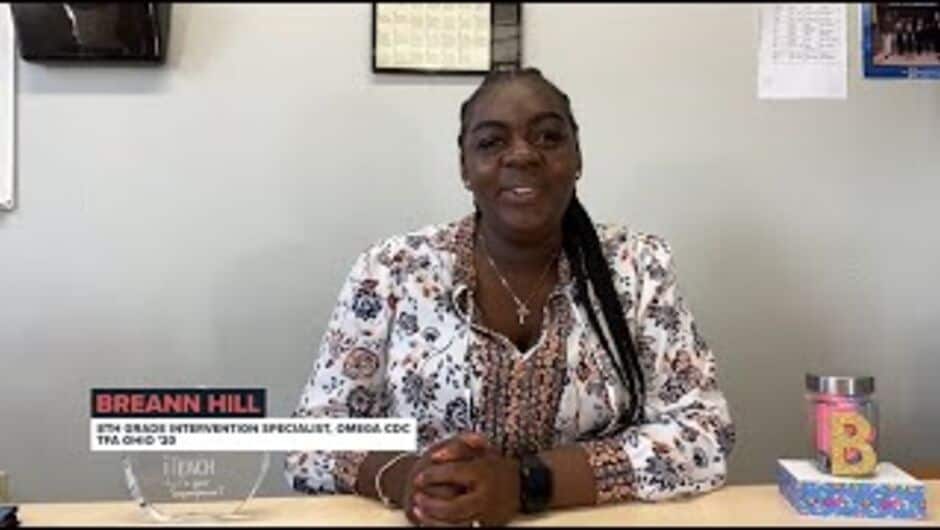 A woman sits at a desk.