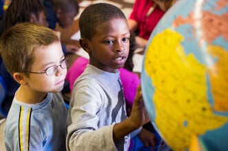 Students look at a globe.