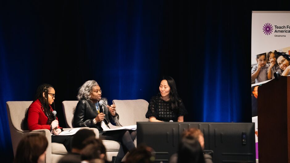 Three women having a panel discussion at a conference.