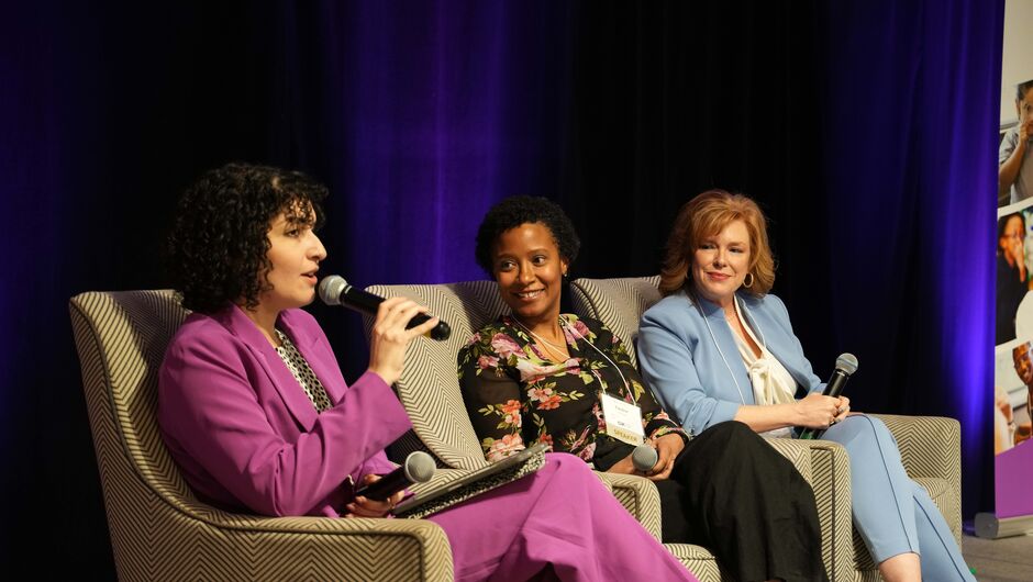 Three women having a panel discussion at a conference.