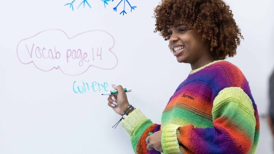 Alt Text: Corps member at whiteboard