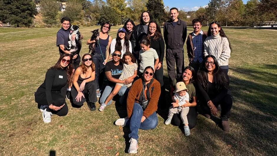 A group of families poses in a field.
