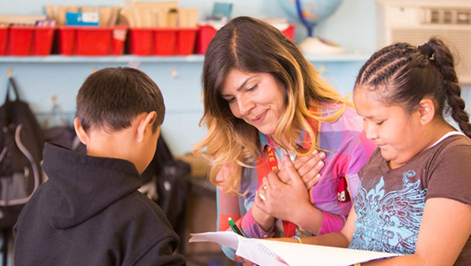 Teacher looks happily at her students' work. 