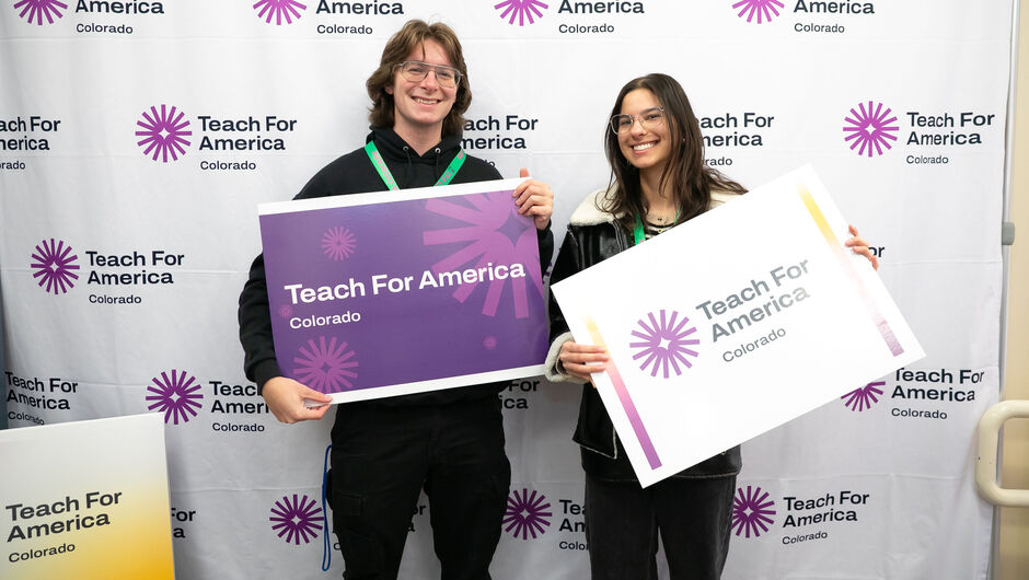Two teachers holding signs that read Teach For America Colorado
