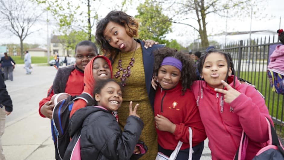 A Teach For America teacher standing outside with her students.