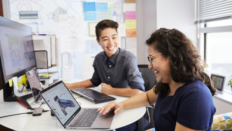 Alt text: Two teachers work together in a computer lab.