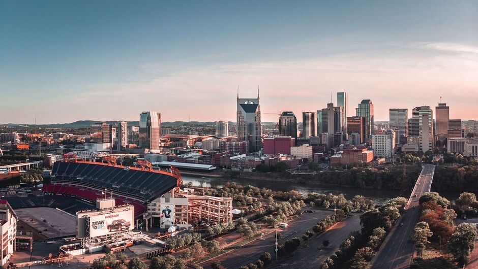A view of Nashville's skyline with tall buildings and a river in the foreground.