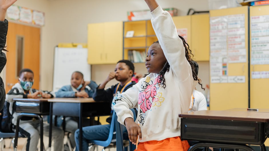 Student raising their hand in class