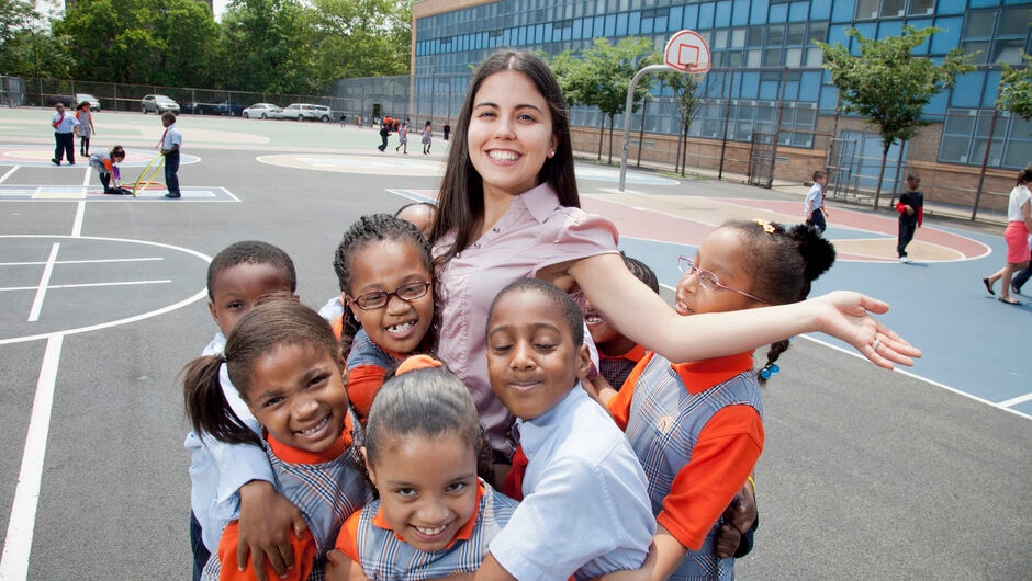 Teach For America teacher being hugged by students