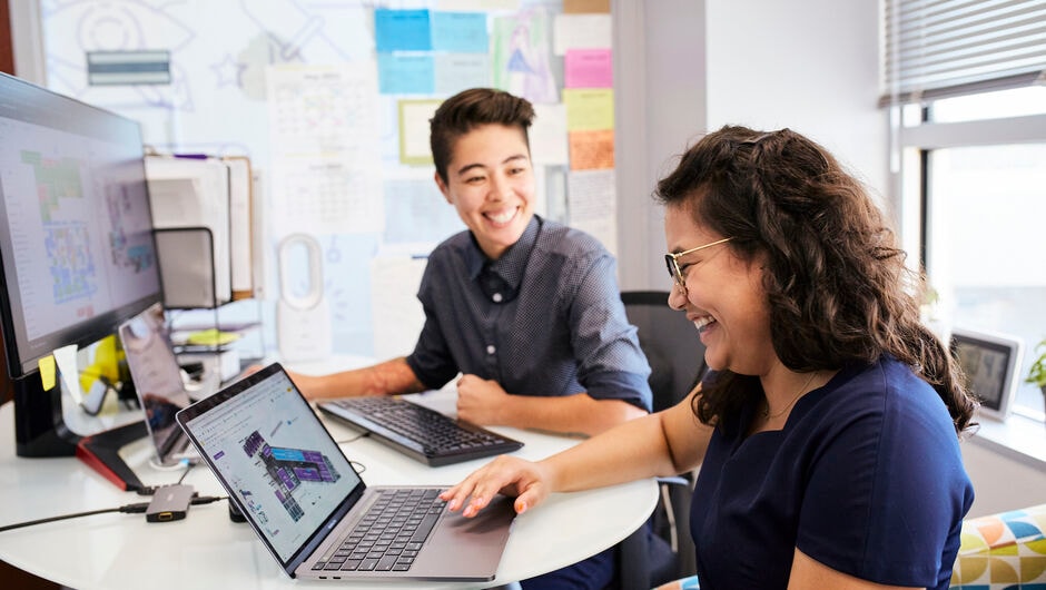 two teachers at a dest smiling